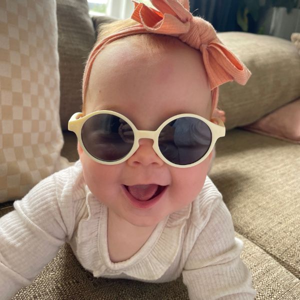 Cloud White Baby Sunglasses with detachable rubber head strap. Round Frames. For babies 6M-3Y old. Image depicts baby girl wearing the White sunglasses.