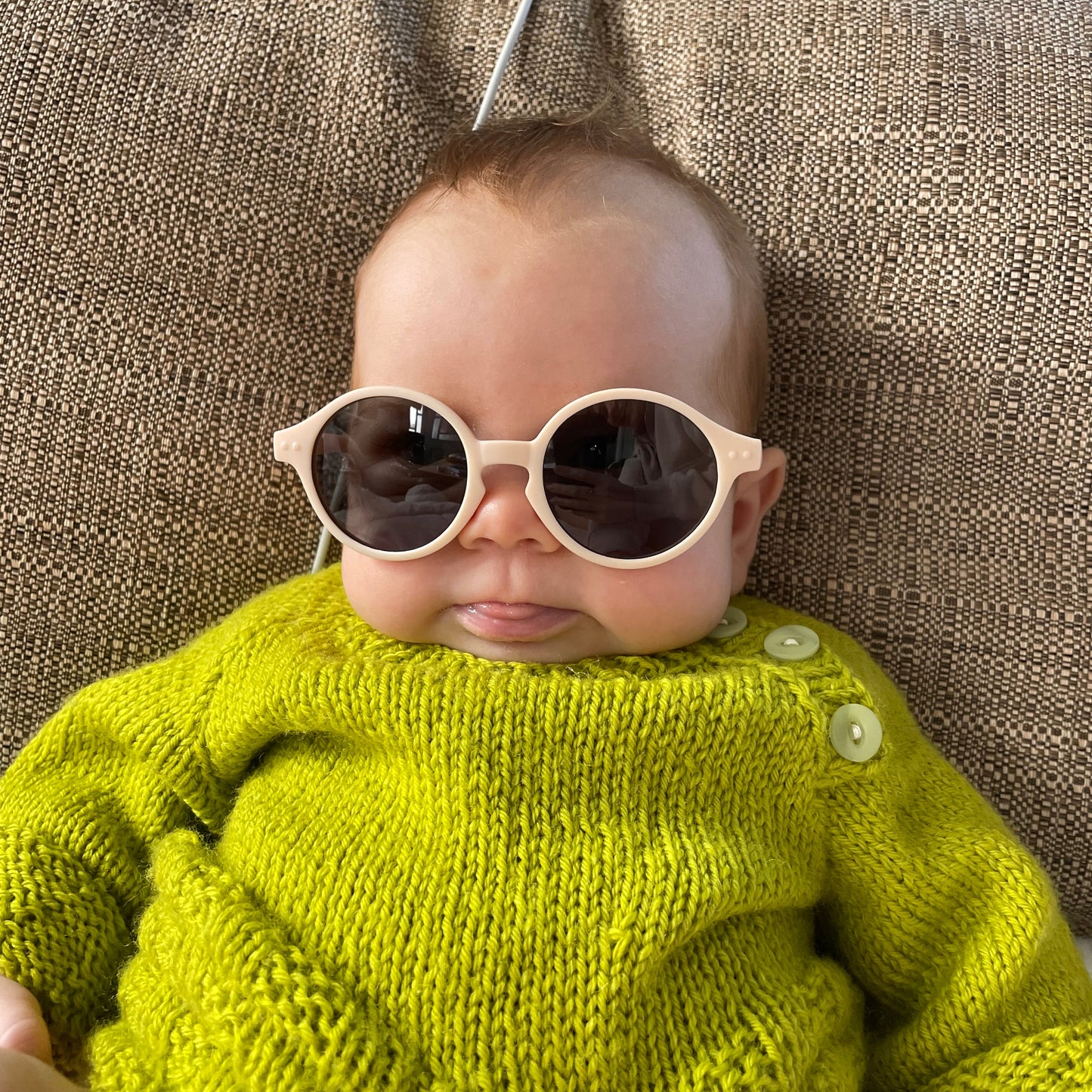 Soft Peach Baby Sunglasses with detachable rubber head strap. Round Frames. For babies 6M-3Y old. Image depicts baby girl wearing the White sunglasses.